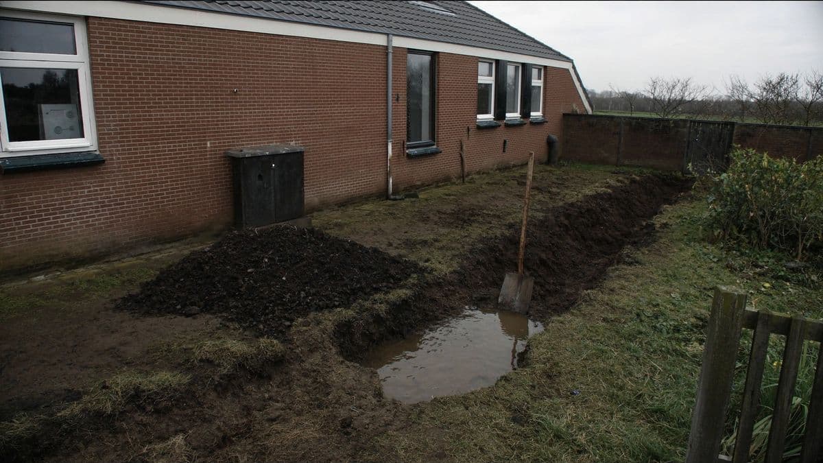 Een gegraven greppel in een Nederlandse achtertuin waarin het grondwater is opgekomen en blijft staan